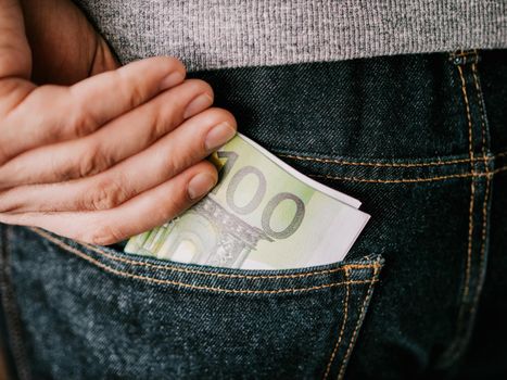 his hand put Euro in jeans pocket or take out from pocket