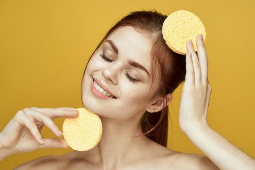 pretty woman with sponges in her hands bare shoulders clean skin hygiene. High quality photo