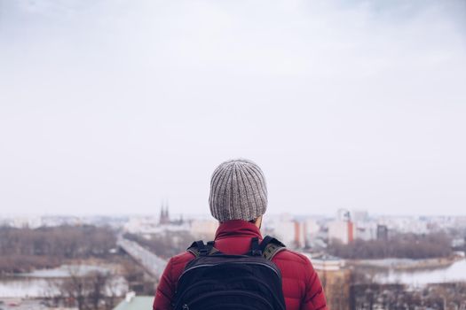 Tourist looking panorama during winter season - City explorer with backpack.