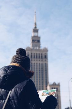 Young tourist with map against the Palace of Culture and Science - Warsaw.