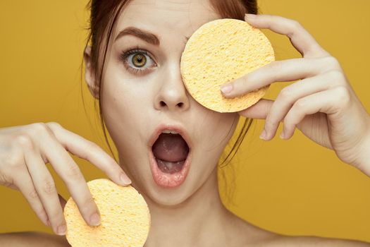 pretty woman with sponges in her hands bare shoulders clean skin hygiene. High quality photo