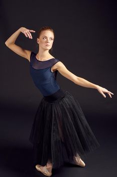 beautiful woman in a black dress dance fashion exercise dark background. High quality photo