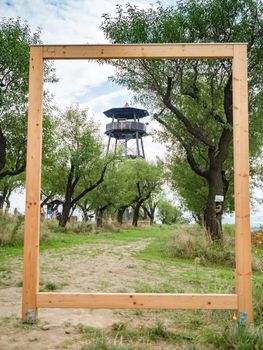 Picture frame with Lookout tower near Hustopece town, placed in almond tree orchard. South Moravia region, Czech Republic