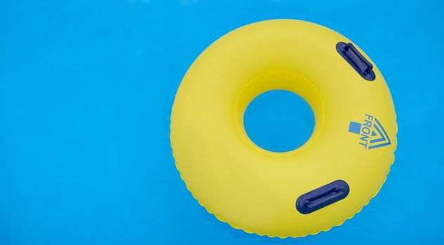 yellow colorful swimming circle with handles with the inscription forward directed to the right . High quality photo