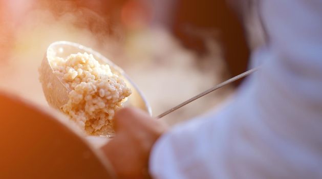 pearl porridge in the ladle is superimposed on a plate of field kitchen. High quality photo