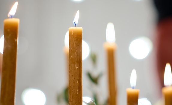 Beautiful burning candles and fairy lights at table with bokeh. High quality photo