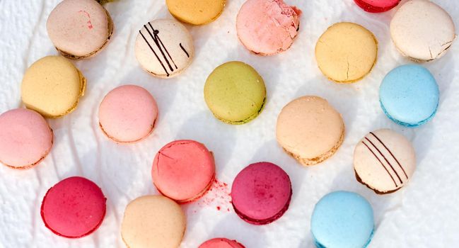 Colorful macaroons on the table covered with a white tablecloth . High quality photo