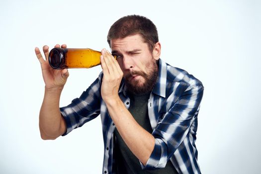 a man in a plaid shirt beer alcohol emotions fun light background. High quality photo