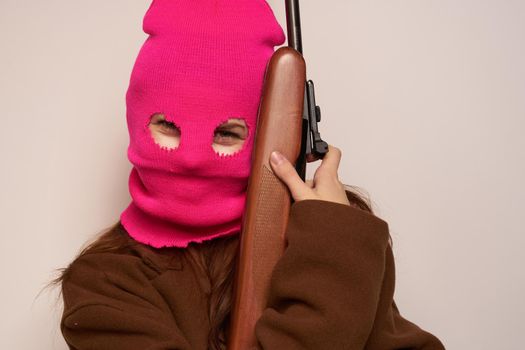 female shooter with a gun in hand Lifestyle beige background. High quality photo