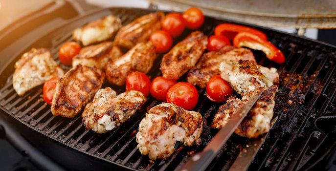 juicy roasted meat, tomatoes, red pepper on the grill on the street. High quality photo