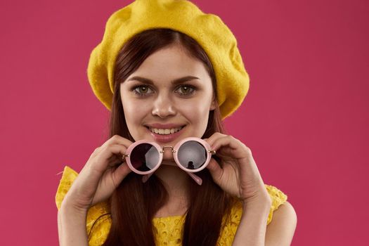woman in yellow hat sunglasses pink background. High quality photo