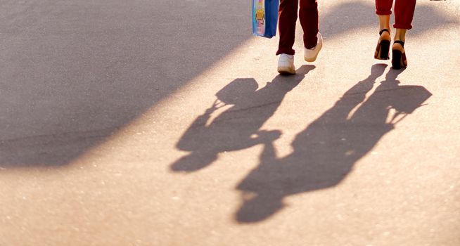 Shadow and part of the legs of a woman's mother and son's baby who go to school. High quality photo