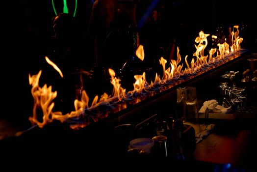 A cake with lit candles and a fireplace. High quality photo