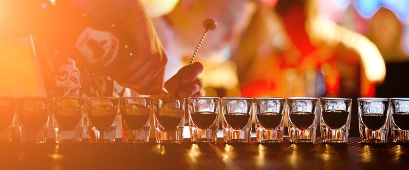 Bartender fills glasses stack cooks a lot of b52. High quality photo