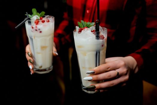 Girl waiter with two milkshakes in hand. High quality photo