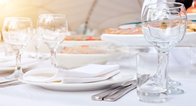 Beautiful festive table of luxury plates, glasses and cutlery served for wine tasting. Close up, blur background. High quality photo