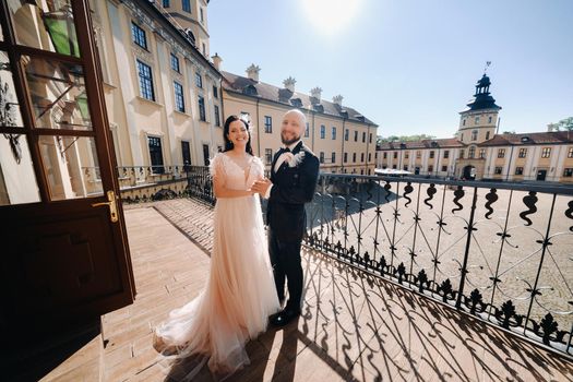 Elegant wedding couple on the balcony of an old castle in the city of Nesvizh.