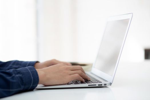 Hand of business man working from home using laptop computer to internet online on desk, lifestyle of new normal, social distancing, freelance work in stay home, employee using notebook indoor.