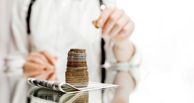 woman carries a coin to put it in a stack of coins located on the banknote . High quality photo