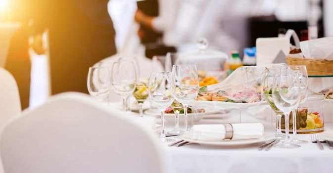 Beautiful festive table of luxury plates, glasses and cutlery served for wine tasting. Close up, blur background. High quality photo