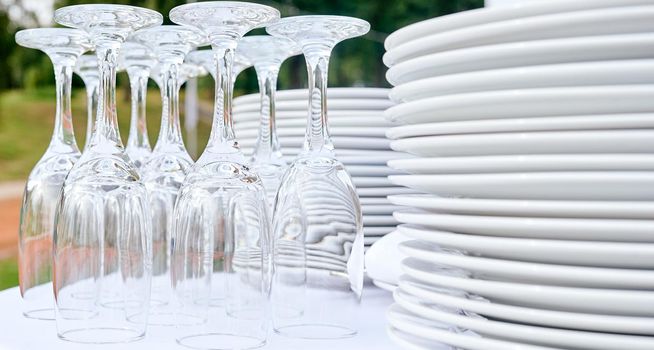 Catering services. closeup Glasses without wine and plates background at outdoor party. High quality photo