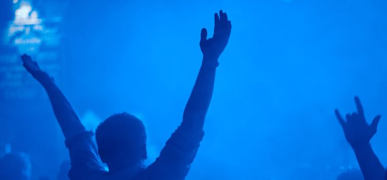 satisfied man at the party back with his hands up . High quality photo