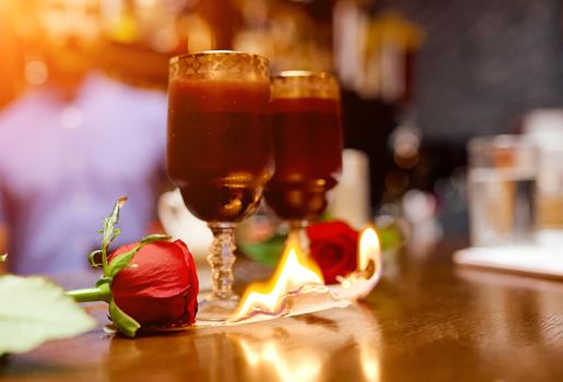 cocktail in two glasses is worth burning paper with two roses . High quality photo