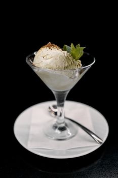 ice cream in a glass on a plate with spoon