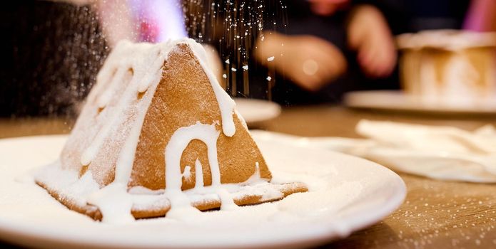 A close up of Gingerbread house under snow. a piece of cake. . High quality photo