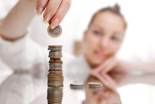 A woman shifts from three stacks of coins into one. High quality photo