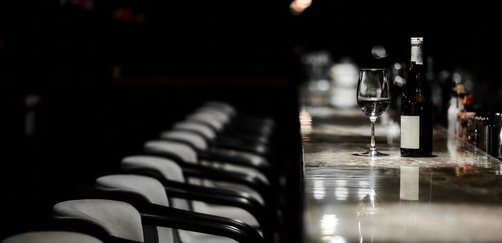 Bar table, chairs, bottle and glass in night place. High quality photo