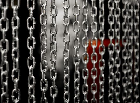 several near chains hanging parallel to each other with sides in the background. High quality photo