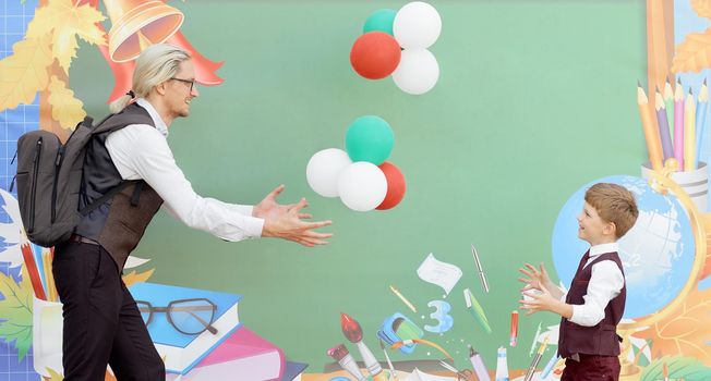 father play with son balloons on school background in first study day . High quality photo