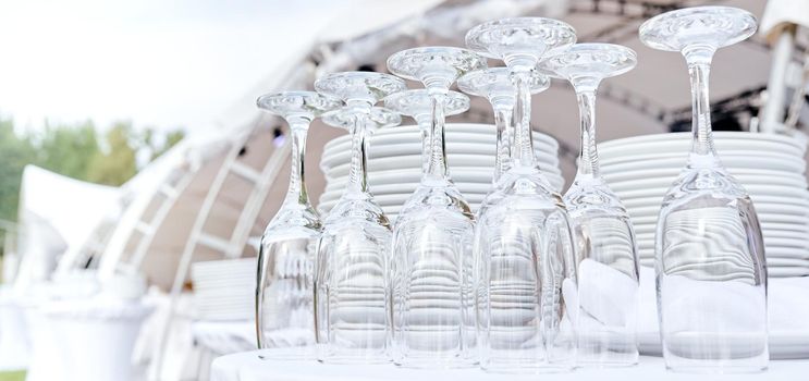 Catering services. closeup Glasses without wine and plates background at outdoor party. High quality photo