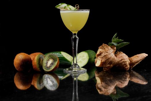 Cocktail of kiwi, ginger, cucumber on a black background on a mirrored table. High quality photo
