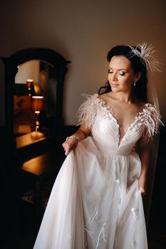 Portrait of the Bride in a wedding dress in the interior of the house near the mirror.