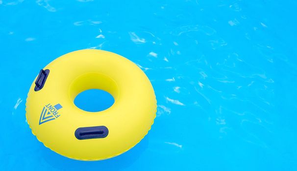 yellow lifeline with the inscription front and arrow pointing to the bottom left corner on the water in the pool . High quality photo