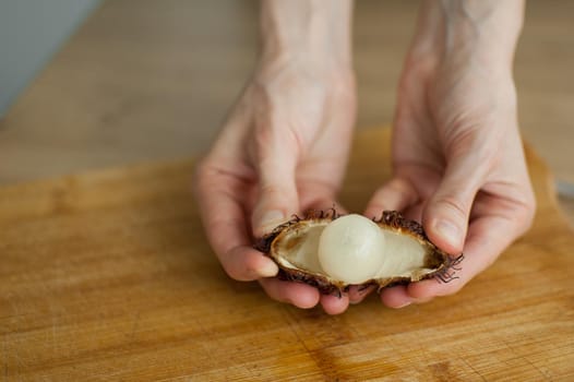 Ripe rambutan and leechy or lychee fruits on wooden table. Healthy food, fresh organic fruit