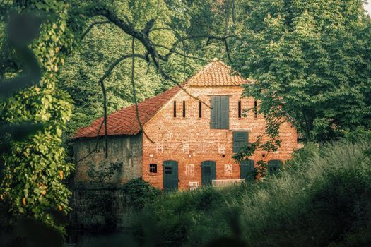 An old idyllic farmhouse in summer on a small river