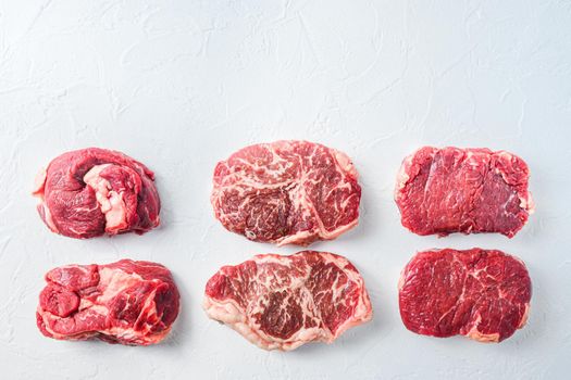 Raw set of alternative beef cuts Chuck eye roll, top blade, rump steak. Organic meat. White textured background. Top view with space for text