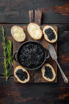 Sandwiche with black caviar, on old dark wooden table background, top view flat lay