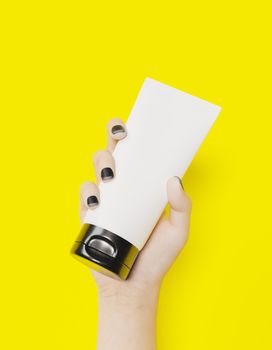 white female hand holding a jar of cosmetic cream on yellow background. mockup. 3d rendering