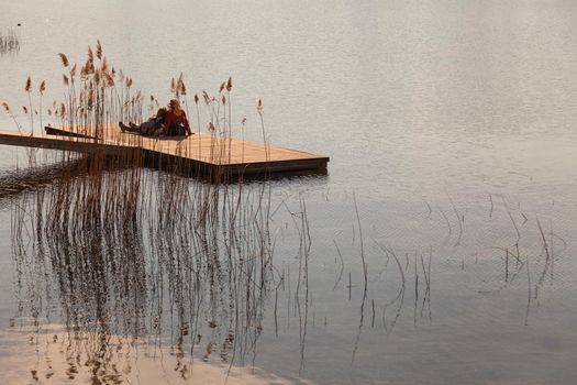 Two aged peoples relaxing at the lake of Annone in italy