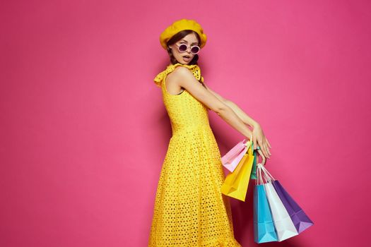 pretty woman wearing sunglasses posing shopping fashion pink background. High quality photo