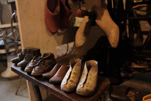 old workshop of a cobbler shoemaker with old shoes and patterns and work tools