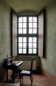 Medieval fortress Cabinet with writing desk with a book and wooden brown chair - interior furniture