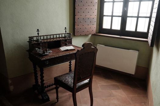 Medieval fortress Cabinet with writing desk with a book and wooden brown chair - interior furniture