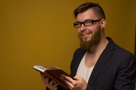 bearded man in a black jacket with a book in his hands education. High quality photo