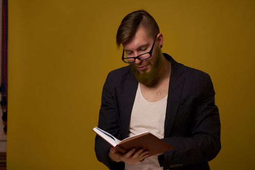 bearded man in a black jacket with a book in his hands education. High quality photo