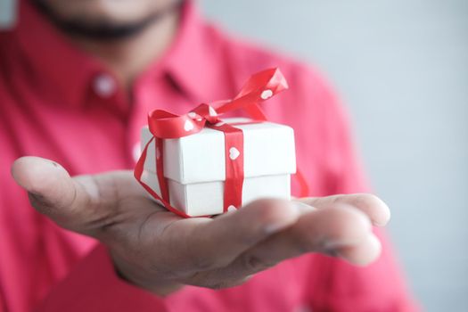 male hand holding gift box, closeup.